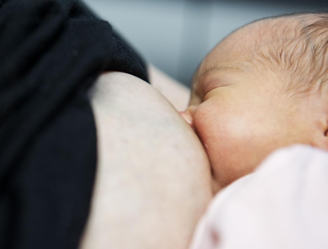 Baby drinkt aan borst van mama